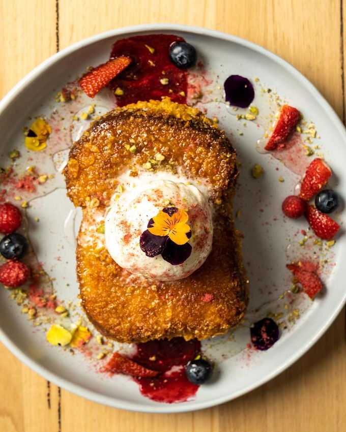 French toast stack topped with vanilla ice-cream, fresh berries and pistachio