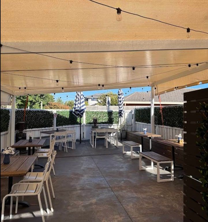 The covered courtyard behind the cafe, edged with greenery