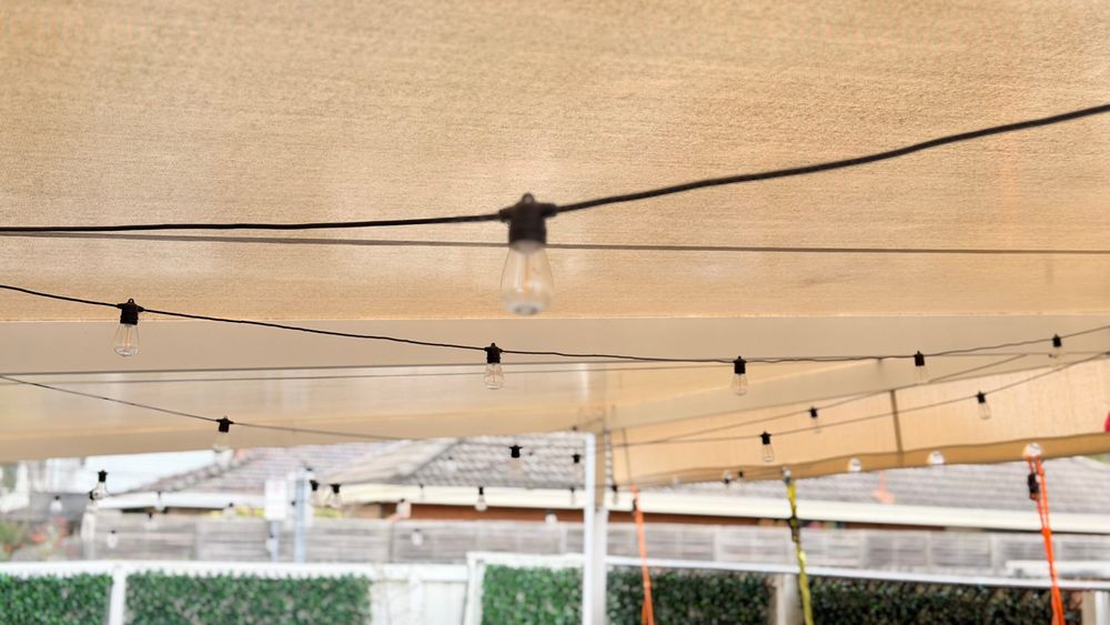 Festoon lights strung under the courtyard's shade awning
