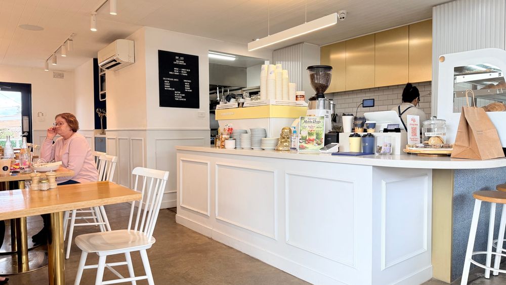 Drip's counter and front dining area, with the coffee machine and menu board behind it