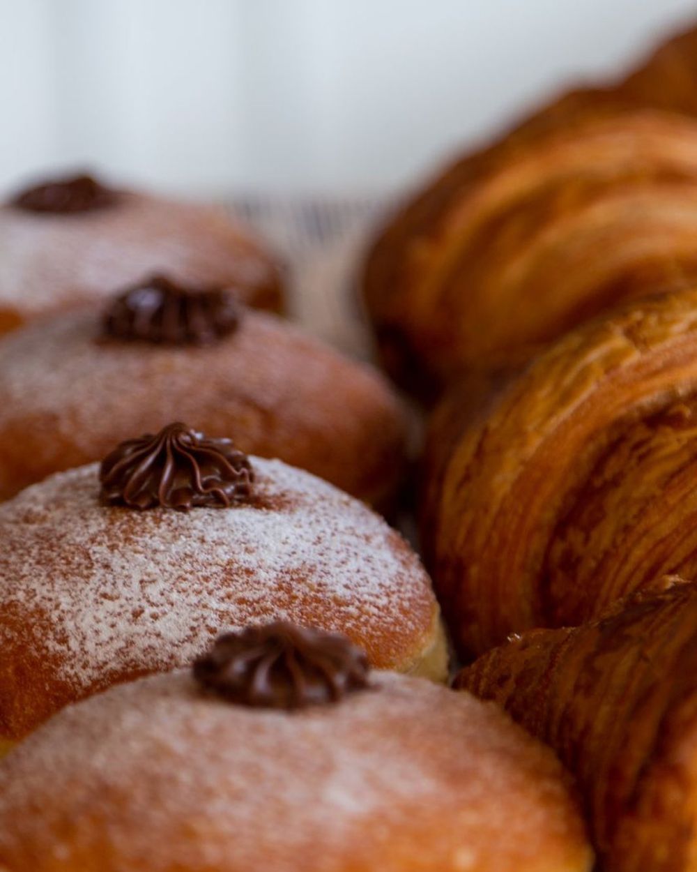 Chocolate-topped doughnuts and croissants on the counter